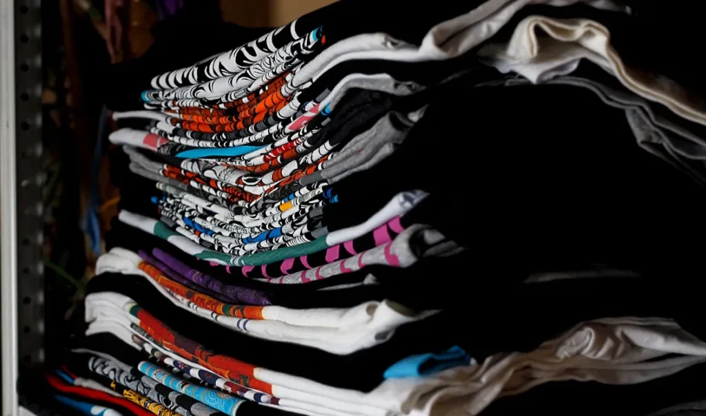 Stack of folded Frelxpew lifestyle graphic tees with unique custom prints on a shelf – Wear Your Story collection.