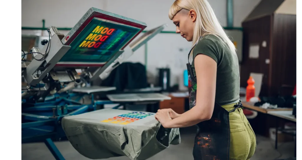 Frelxpew artisan screen printing a custom graphic T-shirt by hand in the workshop.